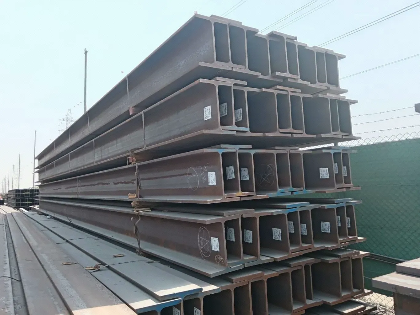 Structural steel sections stacked in the yard